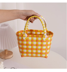 Makro-Detail des handgewebten Schachbrettmusters in Gelb und Orange in der Sommertasche