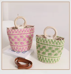Détail de sacs seaux tissés à la main avec poignées rondes en bois et bandoulière cuir