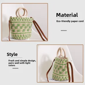 Détail du sac en paille avec anses rondes en bois et motif à carreaux vert en corde