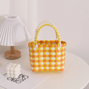 Bunte geflochtene Handtasche mit gelb-orangefarbenem Karomuster für den Sommerurlaub am Strand