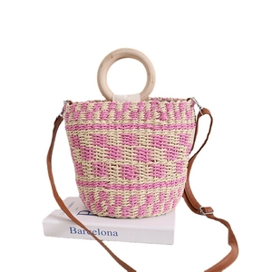 Sac seau en paille rayé rose et beige avec poignées en bois et bandoulière en cuir souple