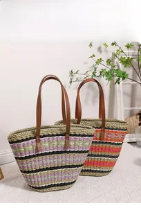 Detail of woven straw tote bags with colorful stripes and leather shoulder straps