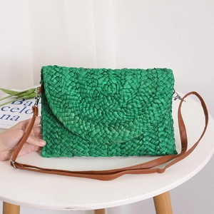 Green corn husk woven crossbody envelope bag with brown faux leather strap