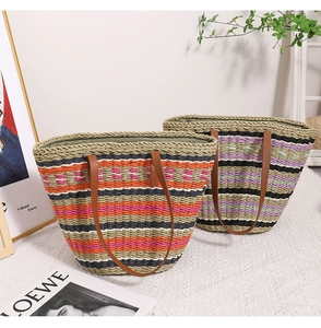 Detail of woven straw bags with striped patterns and premium leather shoulder straps