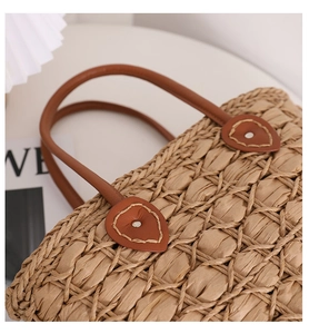 Detailed close-up of woven paper rope texture with brown leather heart patch and rivet