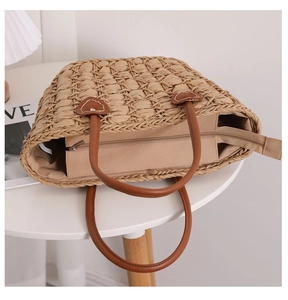 Detail of hand-woven straw tote with leather heart-shaped reinforcement and inner lining