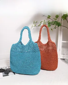 Detail of hollow woven straw tote bags in sky blue and vintage brick red colors