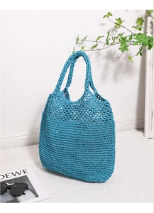 Close-up of royal blue crochet hollow knit texture on a large capacity straw tote bag