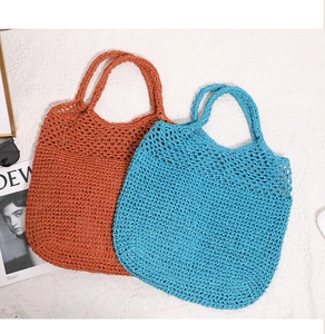 Detailed close-up of hollow crochet texture on straw tote bags in orange and blue