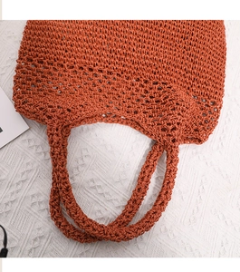 Detailed close-up of the woven pattern and hollow texture of the caramel straw tote bag