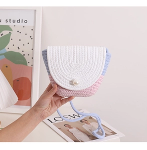 Close-up of small woven crossbody bag with pearl buckle and pastel color-block design