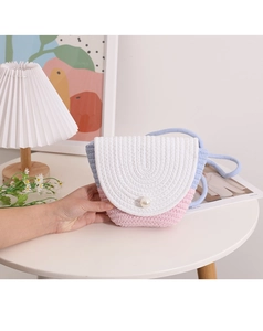 Detail of handmade woven straw bag with pastel color blocks and a faux pearl clasp