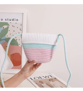 Detail of hand-woven straw crossbody bag featuring tricolor pastel stripes and thick texture