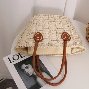 Chic cream straw tote bag with brown heart-shaped leather patch and top handles