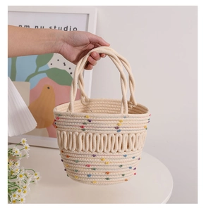 Close-up of cream woven bucket bag featuring 3D wave texture and colorful pom-poms