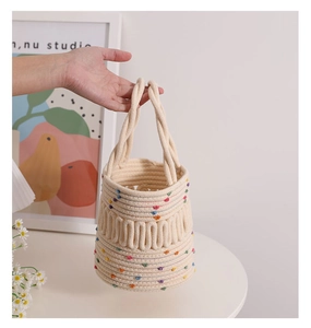 Detail of hand-woven cotton rope bucket bag with colorful polka dots and sturdy top handles