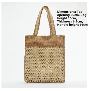 Détail du tissage au crochet ajouré et des poignées contrastées du sac en paille