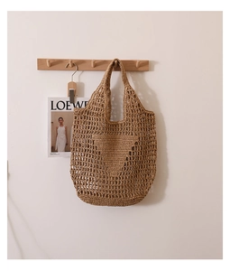 Detail of hollow-out straw tote bag featuring intricate triangular woven patterns and texture