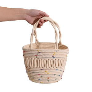 Handmade cream woven bucket bag with colorful pom-pom accents and double handles
