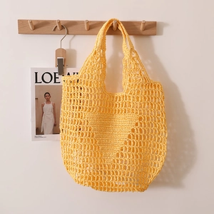 Handwoven straw tote bag in bright yellow featuring a hollow mesh design and heart pattern