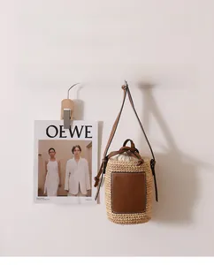 Detail der Raffia-Eimertasche mit braunem Lederpatch und Kordelzug-Innentasche