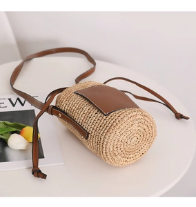 Makroaufnahme einer Bast-Beuteltasche mit Webstruktur und brauner Ledertasche vorne