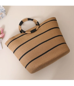 Detail of striped straw tote bag featuring round handles and natural woven texture