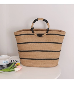 Detailed macro shot of striped straw tote bag featuring round handles for summer beach style