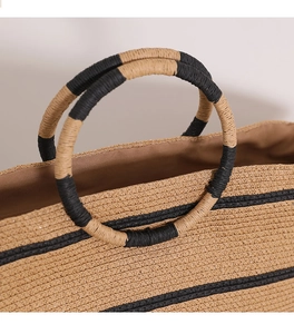 Detail of round ring handle with black and yellow wrapping on a striped straw tote