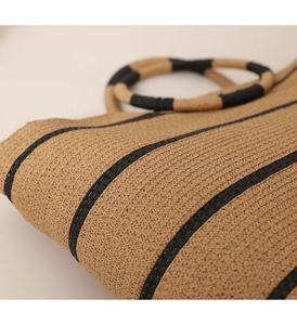 Detail of hand-woven striped tote bag with textured material and ring handle