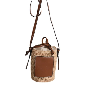 Stroh-Eimertasche mit braunem Lederpatch und verstellbarem Umhängeriemen