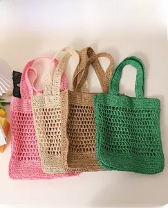 Detail of hollow woven straw bags in pink, beige, camel and green for beach vacation