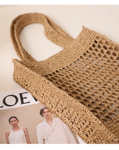 Close-up of brown woven hollow mesh tote bag with wide shoulder handles for beach vacations