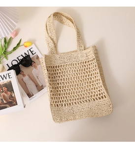 Flat lay of a beige woven straw beach bag with sunglasses and floral summer accessories