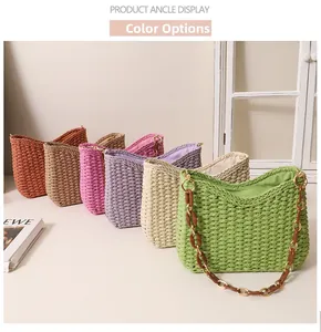 Detail showing various colors of woven straw tote bags with decorative ring chain handles
