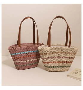 Close-up of hand-woven straw tote bags with colorful stripes and long brown handles