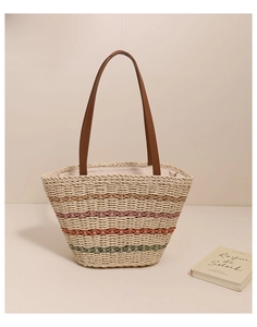 Detailed texture of a colorful striped woven straw tote bag with brown leather handles