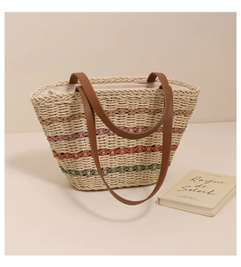 Close-up of colorful striped straw tote bag featuring detailed woven texture and leather straps