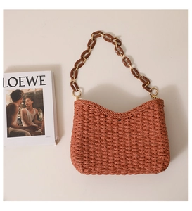 Detail of orange woven straw shoulder bag with stylish brown resin chain strap link