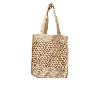 Minimalist straw tote bag with hollow mesh design for summer beach and vacation look
