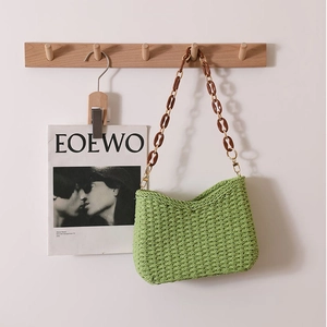 Straw woven tote bag in green with brown resin chain strap for beach vacations
