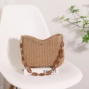 Handwoven straw tote bag in tan with decorative acrylic and gold chain strap