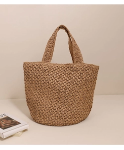 Dettaglio di intricati motivi all'uncinetto su questa grande borsa tote in paglia beige