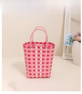 Detail of pink and white checkered woven tote bag with sturdy round handles and metal rivets