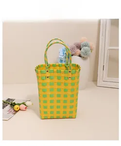 Detailed view of yellow and green checkered woven basket bag with metal rivet handles