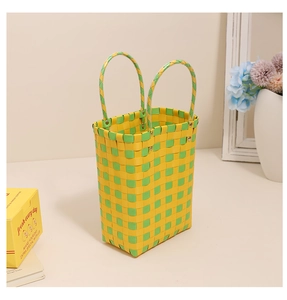 Detail of yellow and green checkered woven basket with reinforced metal rivet handles