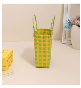 Detailed view of yellow and green checkered woven tote bag made of waterproof plastic