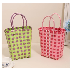 Detail of colorful hand-woven plastic tote bags with sturdy round handles and metal rivets