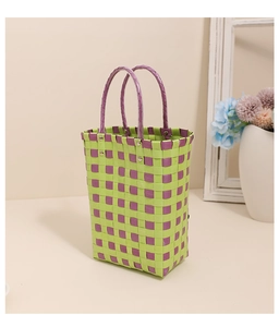 Detail of checkered woven plastic tote bag in vibrant neon green and purple with round handles