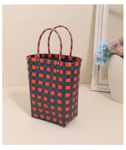 Macro shot of vertical checkered woven bag showing silver rivet detail and red grid texture